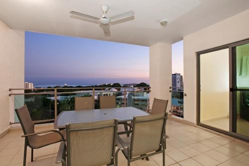 a dining room with a table and chairs on a balcony at Argus Apartments Darwin in Darwin