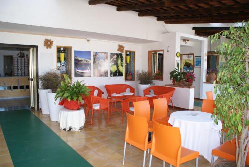 a restaurant with orange chairs and tables in a room at Hotel Cristina in Diamante