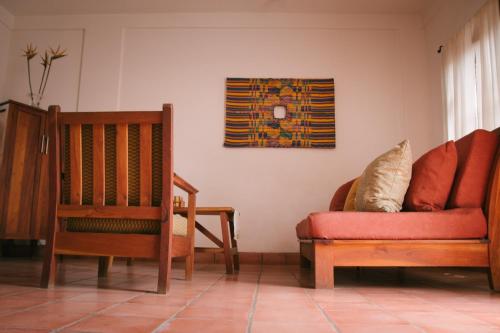 a living room with two chairs and a couch at La Casa de Don Santiago Townhouse in Copan Ruinas