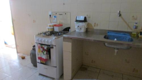 uma cozinha com um balcão, um fogão e um lavatório em Casa de Férias no Porto das Dunas em Aquiraz