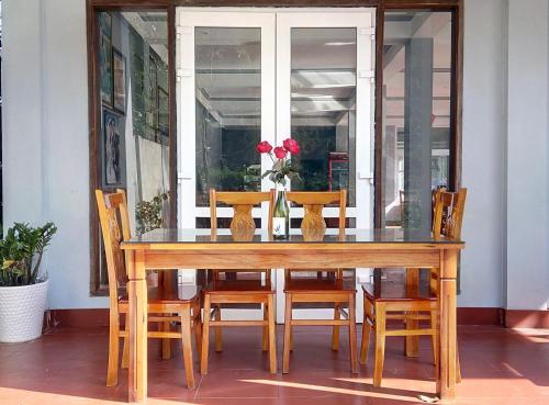 a dining room table with wooden chairs and a glass table at Phong Nha River House in Phong Nha