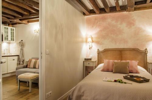- une chambre avec un lit et une chaise dans l'établissement Le Merlot du Marais, à Paris