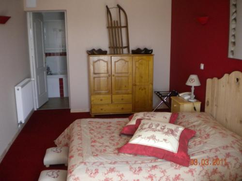a bedroom with a large bed and a dresser at L'Epicurien in Saint-Nicolas-de-Port