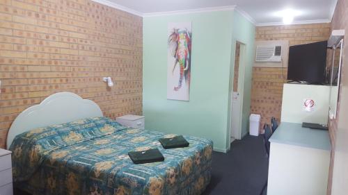 a bedroom with a bed and a brick wall at Tiaro Motor Inn in Tiaro