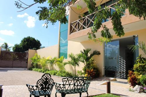two chairs in front of a building at Hotel Roazi in Tizimín