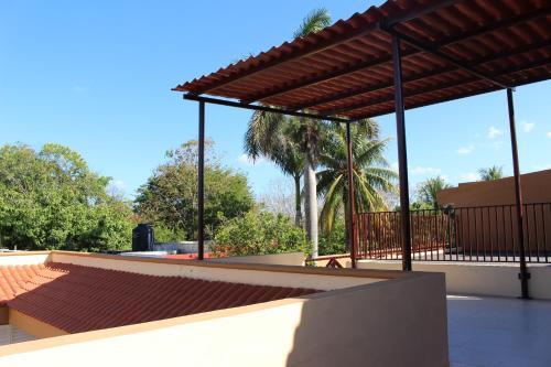 a patio with a pavilion and a palm tree at Hotel Roazi in Tizimín
