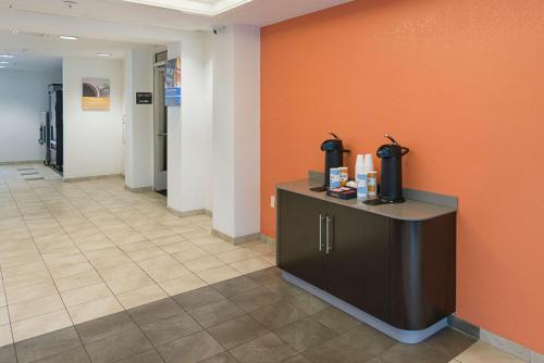 a waiting room with a counter and orange wall at Motel 6-Columbia, SC - Fort Jackson Area in Columbia