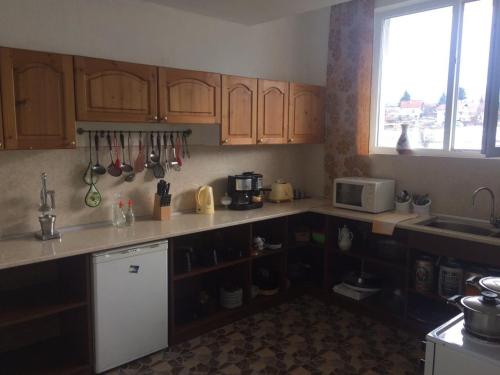 a kitchen with wooden cabinets and a counter top at Atanasovata Kashta in Govedartsi