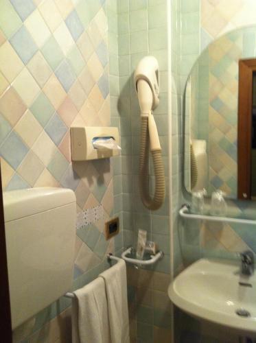 a bathroom with a phone on the wall next to a sink at Hotel Villa Tiziana in Venice-Lido