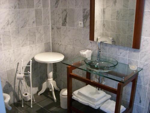 a bathroom with a glass sink and a stool at L'Epicurien in Saint-Nicolas-de-Port