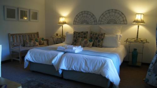 a bedroom with a large bed with two pillows at Cunningham Cottage Guest House in Kuruman