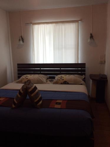 a bedroom with a large bed with a window at Mountain View GuesthouseChiangmai in Chiang Mai