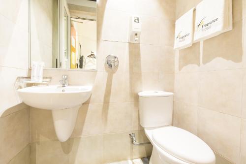 a bathroom with a toilet and a sink at Fragrance Hotel - Balestier in Singapore