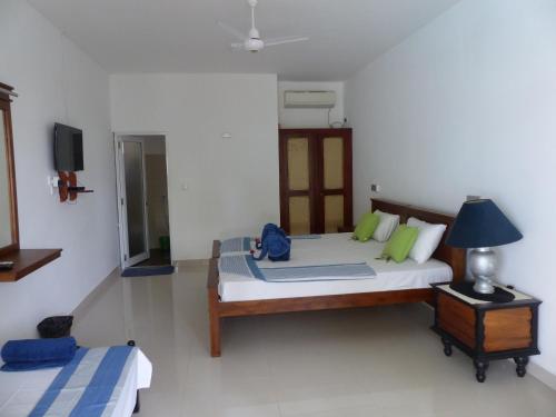 a bedroom with two beds and a tv in it at Residence Jasmine in Aluthgama