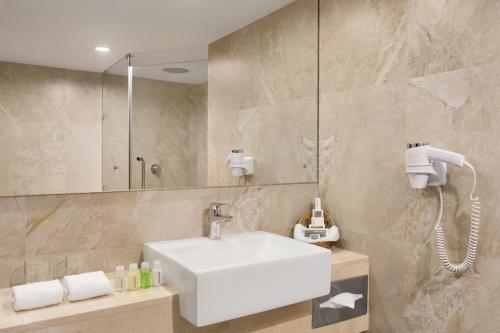 La salle de bains est pourvue d'un lavabo et d'une douche. dans l'établissement Ramada Colombo, à Colombo