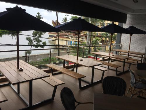 a group of picnic tables with umbrellas in a restaurant at Expressia Hotel Makassar in Makassar