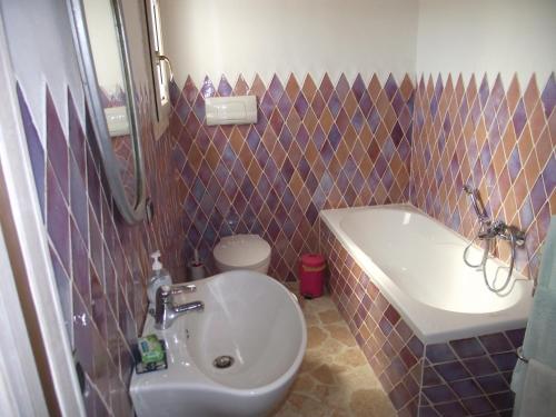 Casa Marcella Cugnana-Portisco في كوغنانا: حمام مع حوض ومرحاض وحوض استحمام