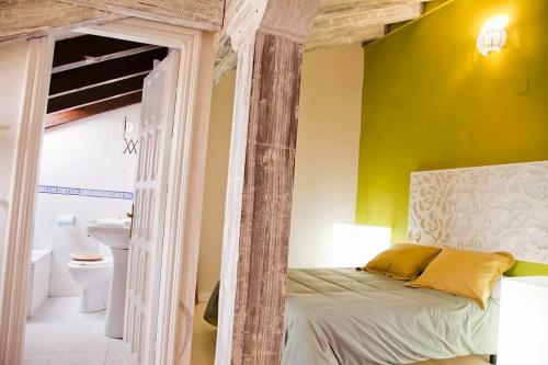 a bedroom with a bed and a yellow wall at La Posada de Langre in Langre