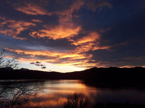 a sunset over a body of water with mountains at Landhotel Grünberg am See in Gmunden