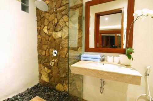 bagno con lavandino e parete in pietra di Narada House Ubud ad Ubud