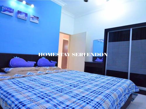 um quarto com uma cama com uma parede azul em Seri Endon Apartment em Shah Alam