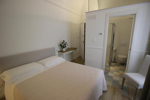 um quarto branco com uma cama e uma casa de banho em Novella 55 em Gravina in Puglia