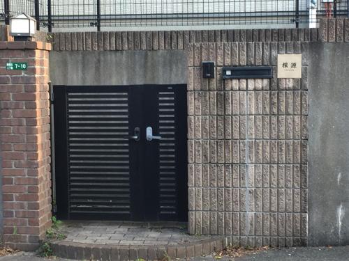 a black garage door in a brick wall at South Wind Chalet in Itoshima