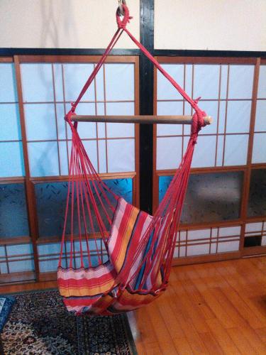 a red hammock hanging in a room at Madarao Farm in Nakano