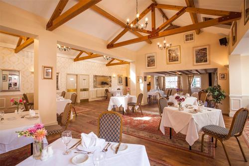 a dining room with white tables and chairs at The Cottage Hotel in Nottingham