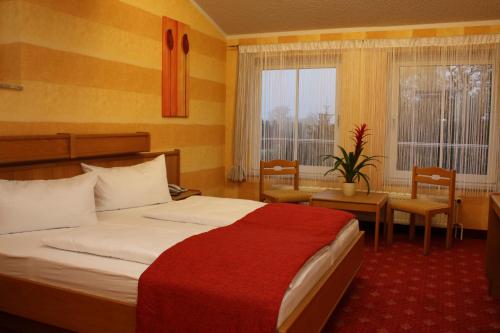 Habitación de hotel con cama, mesa y sillas en Hotel Eleganz, en Rustow