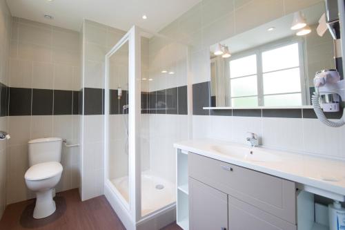 a bathroom with a toilet and a sink and a shower at Savoy Hôtel in Brides-les-Bains