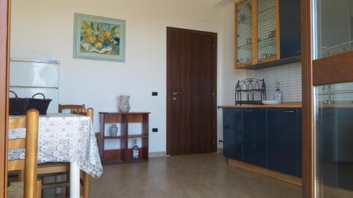 eine Küche mit einem Tisch und einem blauen Kühlschrank in der Unterkunft Il Belvedere vicino Taormina in Savoca 