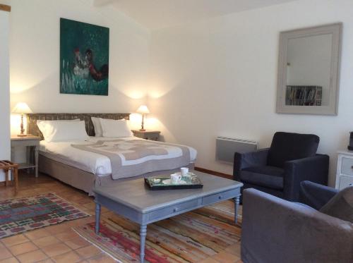 a bedroom with a bed and a chair and a table at Atelier Soleil in Moustiers-Sainte-Marie