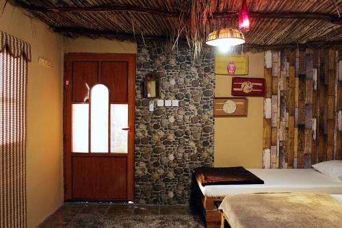 a room with a bed and a door and a window at Al Reem Chalet in Al Ashkharah