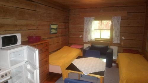 Habitación pequeña con 2 camas y TV. en Metsolan pihapiiri, en Multia