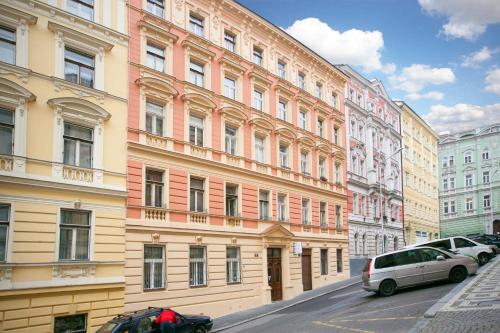 uma fila de edifícios com carros estacionados à frente deles em Central Station Studios em Praga