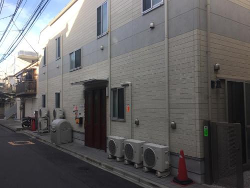 a building with a row of urinals on a street at Yamate Rest House (Male Only) in Tokyo