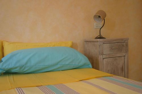 a bed with a pillow and a lamp on a dresser at Antica Corte Leguzzano B&B in San Vito di Leguzzano