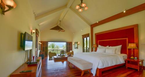 a bedroom with a large bed and a living room at Furama Villas Danang in Danang