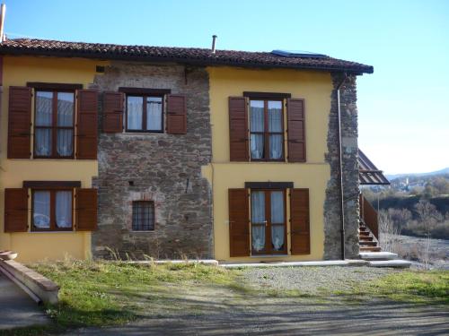 an old stone house with wooden shuttered windows at Cascina Formighezzo in Arquata Scrivia