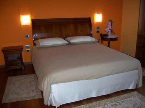 a bedroom with a large bed with white sheets and pillows at Locanda da Gerry in Castelcucco