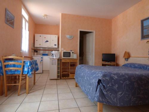 une chambre avec un lit et une petite cuisine dans l'établissement Résidence L'Aquarium, à Arcachon