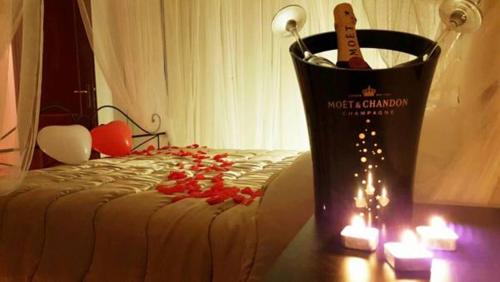 a bedroom with a bed with a bottle of wine and candles at Elegance B&B in Ladispoli