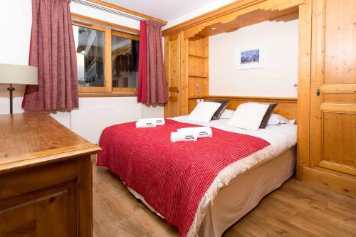 - une chambre avec un lit et une couverture rouge dans l'établissement Les Balcons du Savoy 104 appt - Chamonix All Year, à Chamonix-Mont-Blanc