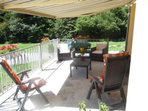 a patio with chairs and a table on a deck at Chambres d'Hôtes La Balaguère in Cauterets