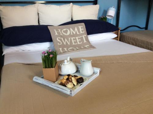 a bed with a home sweet home tray with flowers on it at Sweet Home & Apartments in Fontane Bianche
