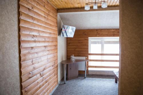 a room with a wooden wall with a table and a window at Hotel & Restaurant Complex HAP-OK in Brodki