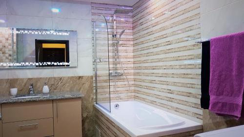 a bathroom with a tub and a shower and a sink at Jasmine Residence Studios in Braşov