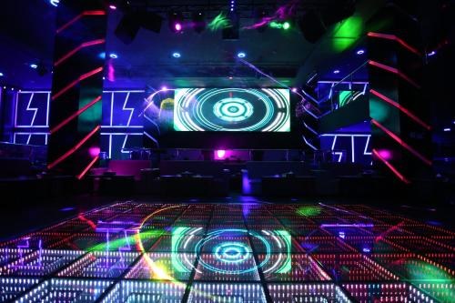 a stage with purple and green lights in a room at Arman Hotel Juffair Mall in Manama