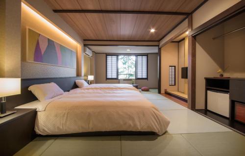 een slaapkamer met een groot bed en een raam bij Oribana in Omachi